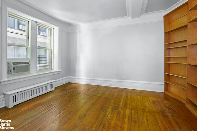 unfurnished room with cooling unit, baseboards, hardwood / wood-style floors, and radiator heating unit