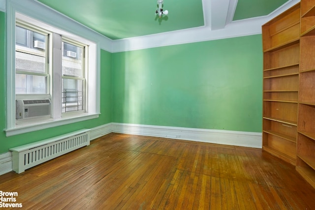 empty room with cooling unit, baseboards, hardwood / wood-style floors, and radiator heating unit