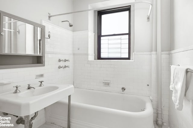 full bath featuring a sink, tile walls, and decorative backsplash