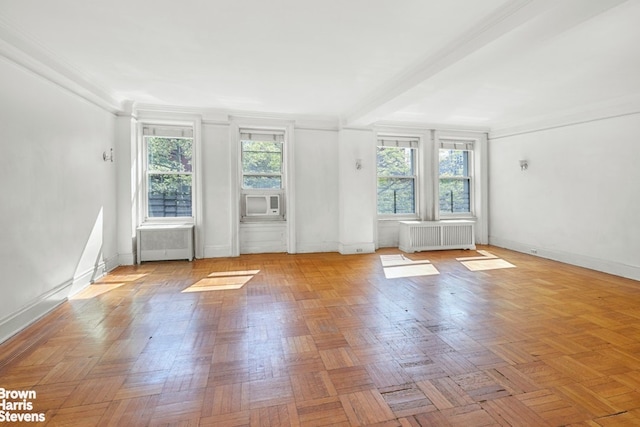 empty room with baseboards, a healthy amount of sunlight, and radiator heating unit