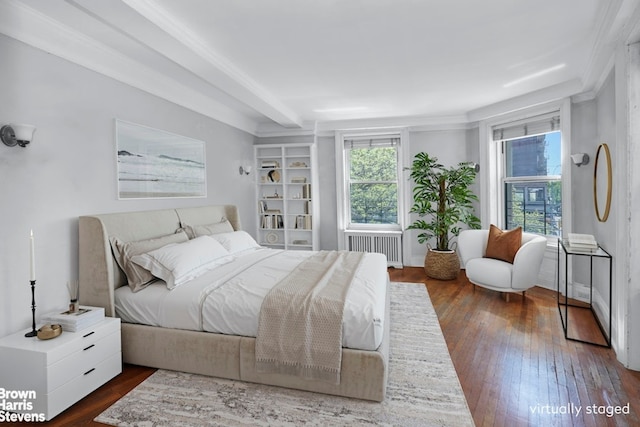 bedroom with radiator heating unit and dark wood finished floors