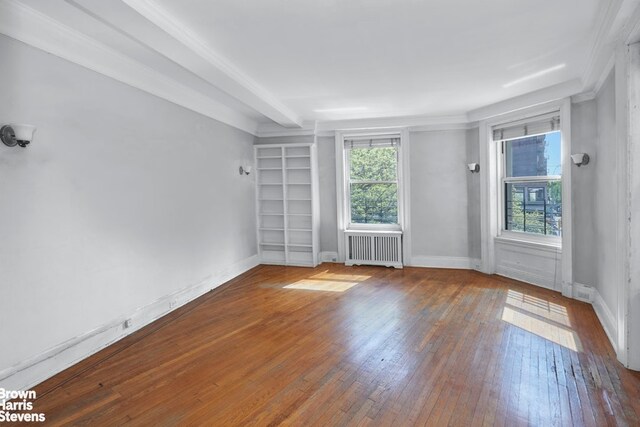 unfurnished room featuring radiator, wood-type flooring, and baseboards