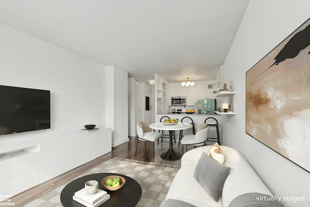 living area with an inviting chandelier and wood finished floors