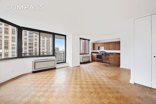 interior space featuring gas stove, brown cabinets, and baseboards