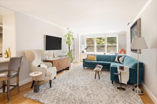 living room with ornamental molding, wood finished floors, and baseboards