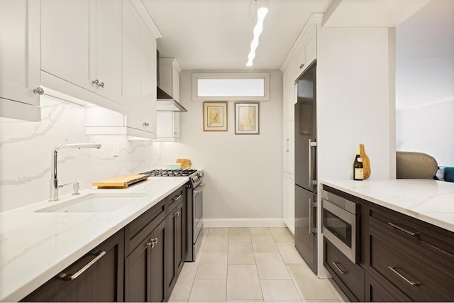 kitchen with tasteful backsplash, dark brown cabinets, built in appliances, white cabinetry, and a sink