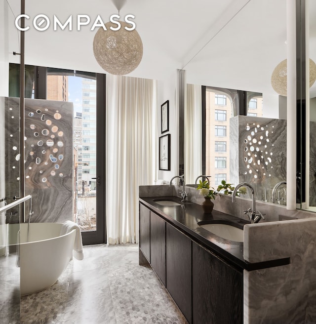 325 W Broadway Unit 7B, New York City, NY 10013 - bathroom featuring plenty of natural light, a freestanding tub, double vanity, and a wall of windows