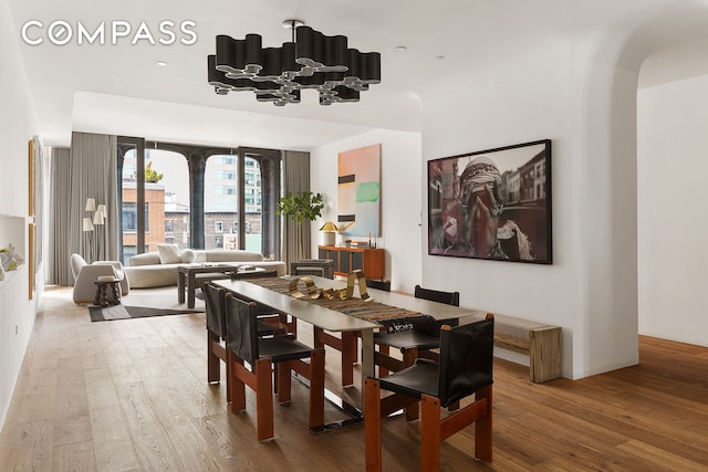 325 W Broadway Unit 7B, New York City, NY 10013 - dining area with wood finished floors, a chandelier, and arched walkways