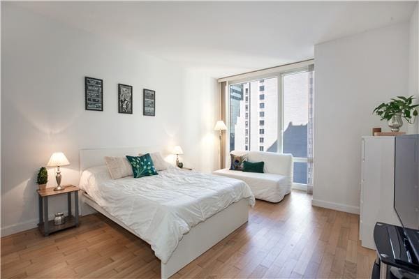 bedroom featuring light wood-style floors and baseboards