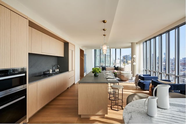 565 Broome St Unit N27B, New York City, NY 10013 - kitchen with wood finished floors, a breakfast bar, modern cabinets, open floor plan, and a center island