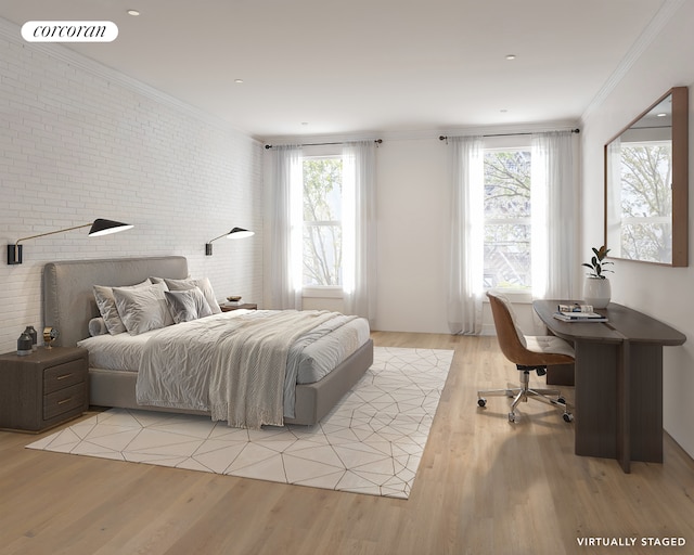 bedroom featuring brick wall, ornamental molding, multiple windows, and light wood-style flooring