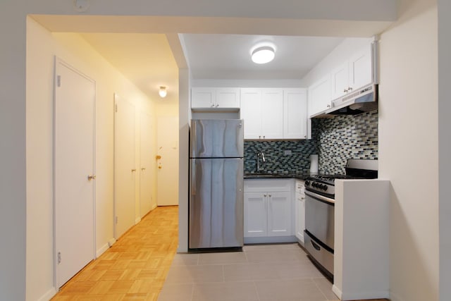 kitchen with under cabinet range hood, a sink, white cabinets, appliances with stainless steel finishes, and backsplash