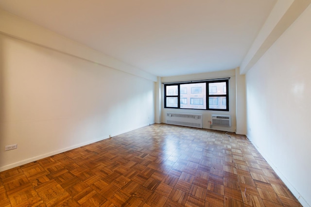 unfurnished room featuring a wall unit AC and radiator heating unit