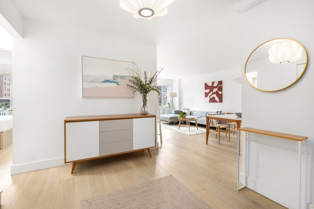 corridor with light wood-style flooring and baseboards