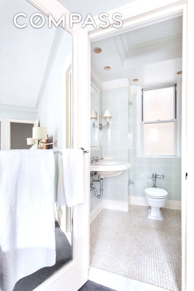 8 E 96th St Unit 7C, New York City, NY 10128 - bathroom featuring crown molding, tile walls, and tile patterned flooring