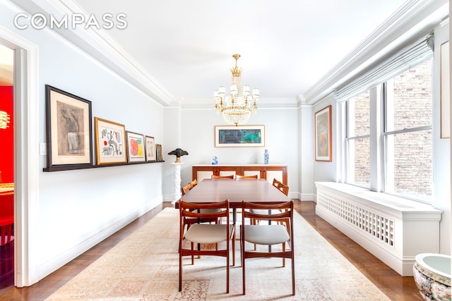 8 E 96th St Unit 7C, New York City, NY 10128 - dining space with a chandelier, crown molding, wood finished floors, and baseboards