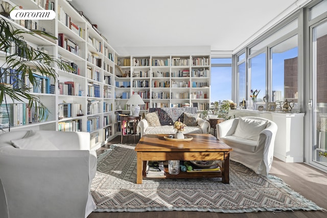 sitting room featuring bookshelves and wood finished floors