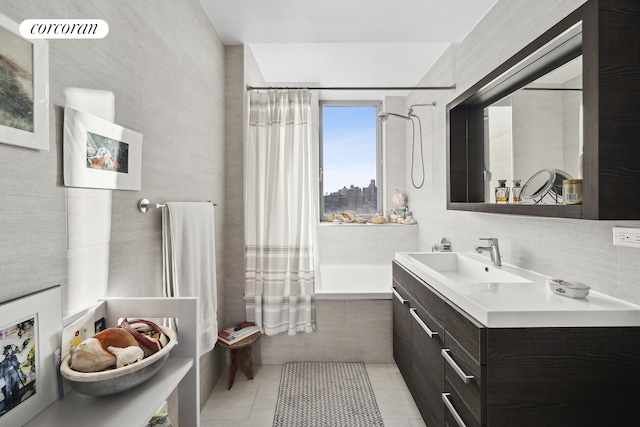 full bathroom featuring tiled shower / bath combo, tile patterned flooring, tile walls, and vanity