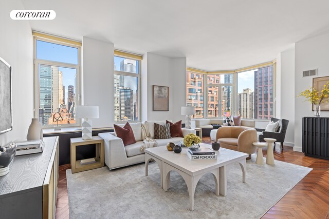 living room with a wealth of natural light, visible vents, and a view of city