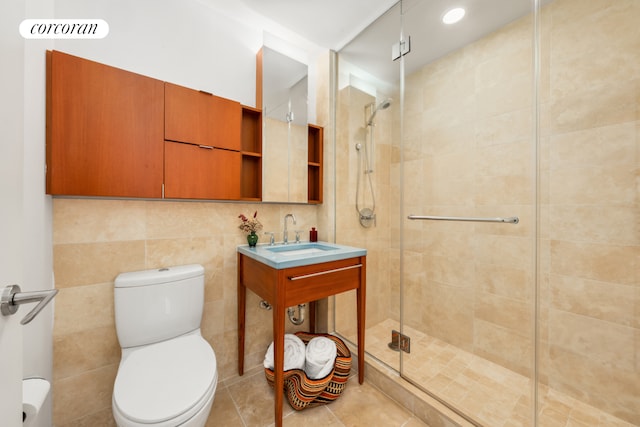 bathroom featuring tile walls, visible vents, toilet, a sink, and a shower stall