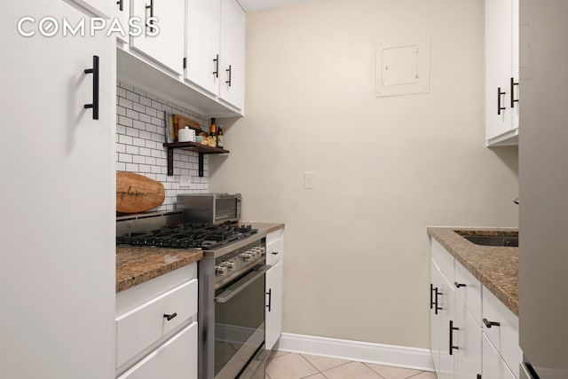 445 E 86th St Unit 8F, New York City, NY 10028 - kitchen with gas stove, tasteful backsplash, light tile patterned flooring, baseboards, and white cabinets