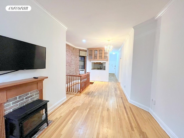 living room with baseboards, visible vents, light wood finished floors, and ornamental molding