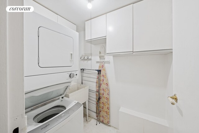 5 W 107th St Unit 1A, New York City, NY 10025 - laundry area with stacked washing machine and dryer and cabinet space
