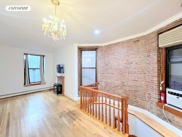 additional living space featuring wood finished floors, visible vents, brick wall, baseboard heating, and a chandelier