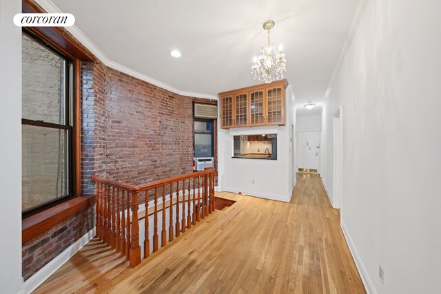 5 W 107th St Unit 1A, New York City, NY 10025 - hallway with an upstairs landing, a chandelier, ornamental molding, light wood-style flooring, and baseboards