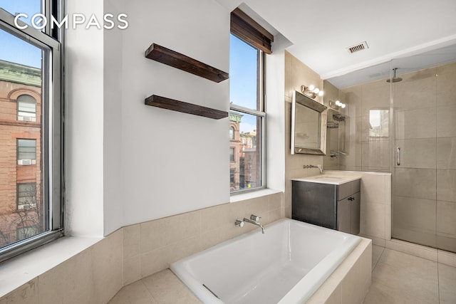 bathroom with a stall shower, visible vents, a garden tub, and vanity