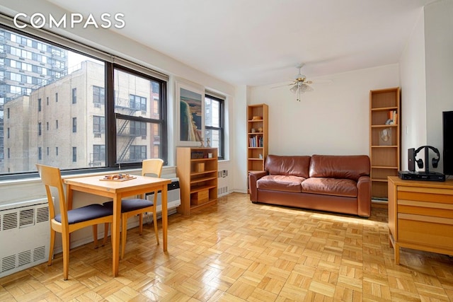 living area featuring radiator and a ceiling fan