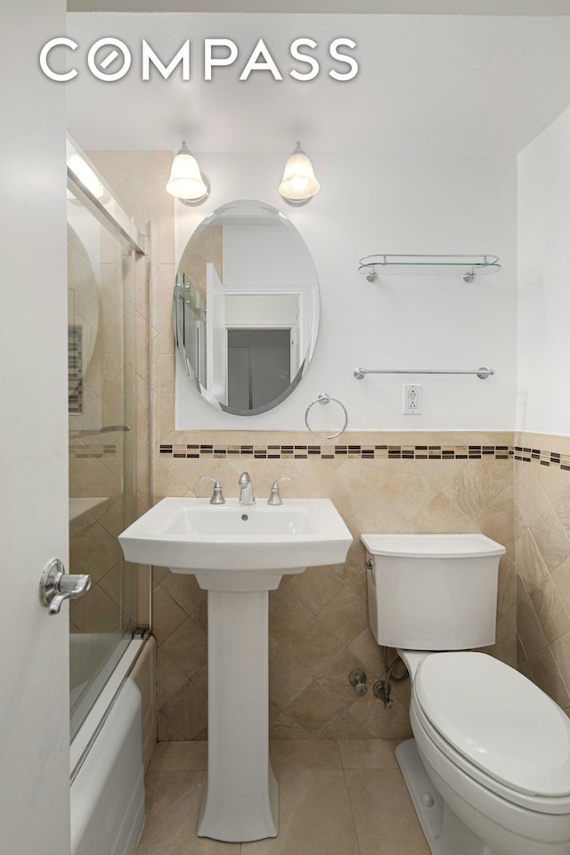 bathroom featuring tile patterned flooring, tile walls, and toilet