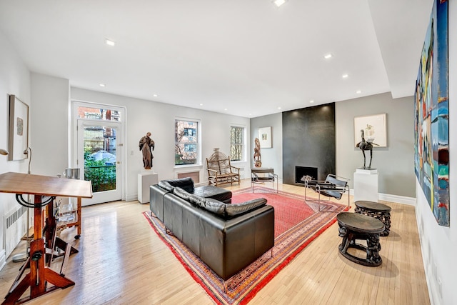 living area featuring light wood-style flooring, baseboards, and recessed lighting