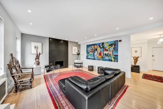 living room featuring baseboards, light wood-style flooring, and recessed lighting