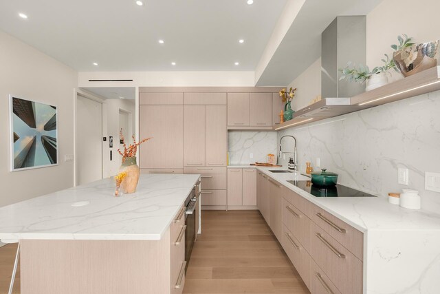 303 W 113th St Ph, Ph, New York City, NY 10026 - kitchen with black electric stovetop, a spacious island, light wood finished floors, recessed lighting, and a sink