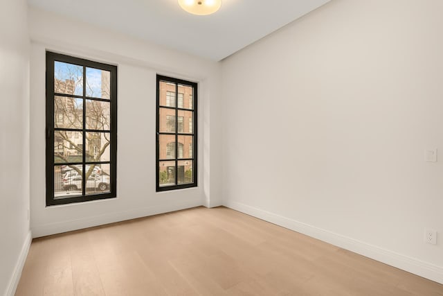 spare room with light wood-style floors and baseboards