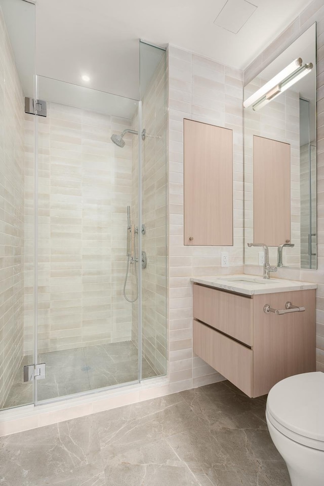 303 W 113th St Unit Th, New York City, NY 10026 - bathroom with vanity, marble finish floor, toilet, tile walls, and a shower stall