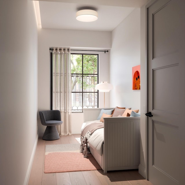 bedroom featuring wood finished floors and baseboards