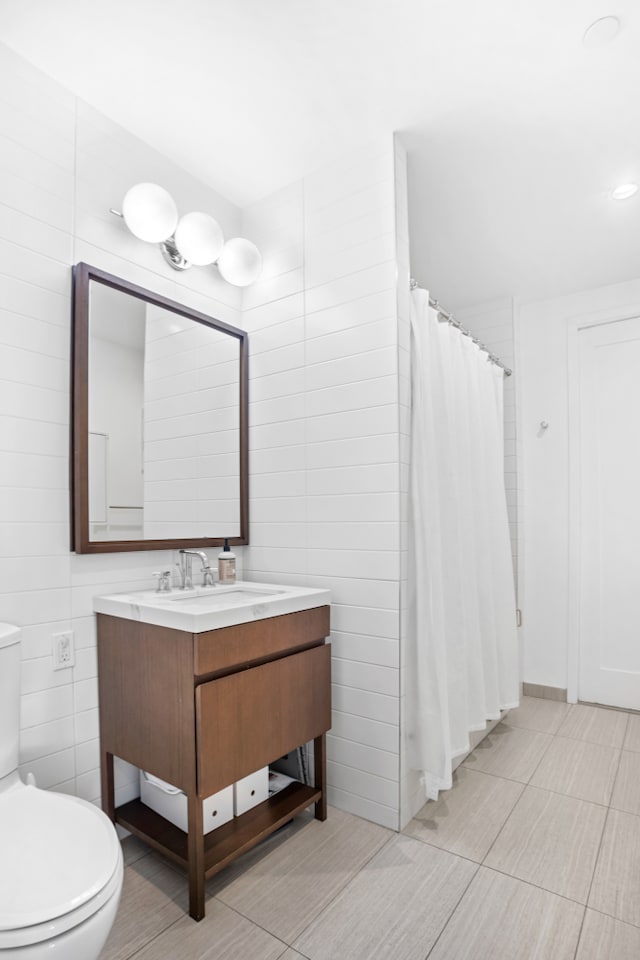 full bath with toilet, a shower with shower curtain, tile walls, and vanity