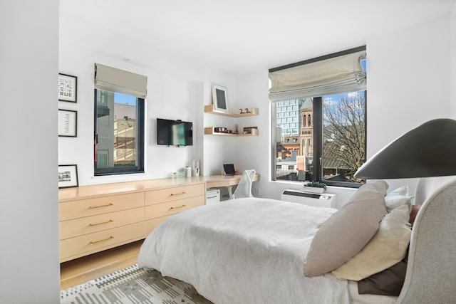 bedroom featuring wood finished floors and built in study area