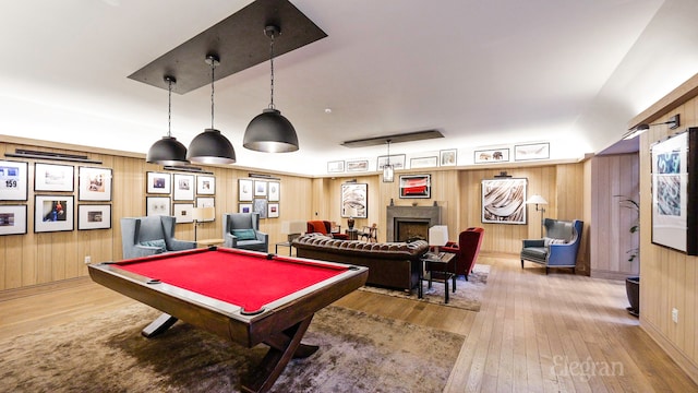 playroom with pool table, wood-type flooring, a fireplace, and wooden walls