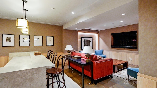 living room featuring recessed lighting, a wainscoted wall, and wood finished floors