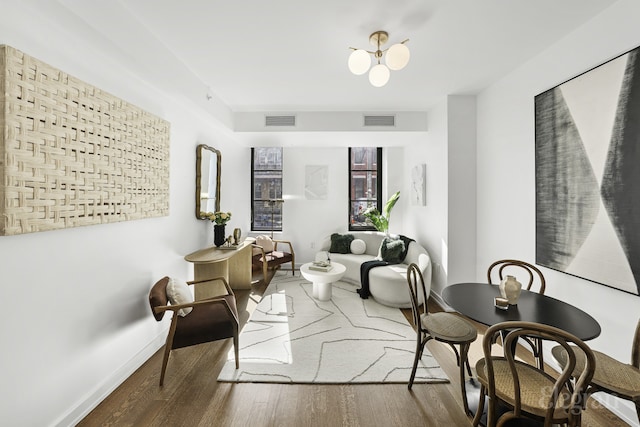 sitting room featuring visible vents, baseboards, and wood finished floors