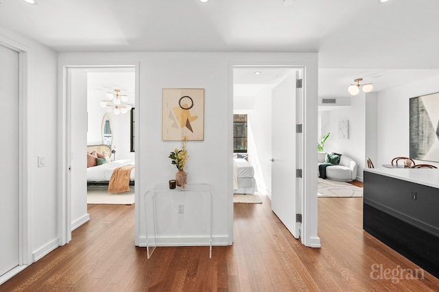 hallway with visible vents and wood finished floors