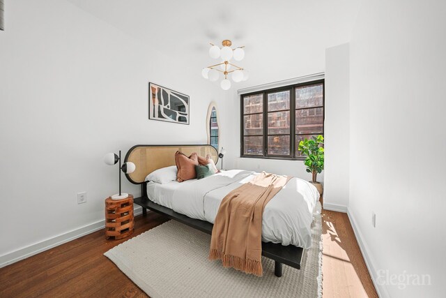 261 W 25th St Unit 1-C, New York City, NY 10001 - hallway with visible vents, wood finished floors, and an inviting chandelier