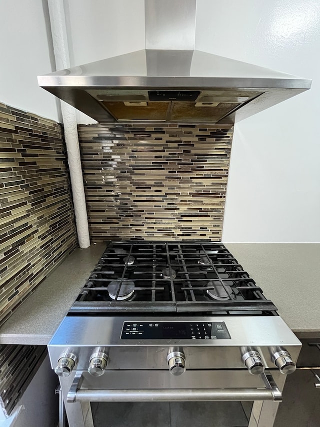 room details with stainless steel gas range oven, ventilation hood, and decorative backsplash