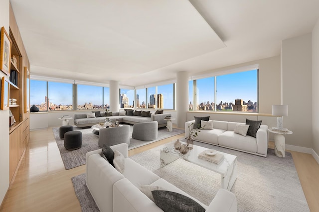 living room with a view of city, light wood finished floors, and baseboards