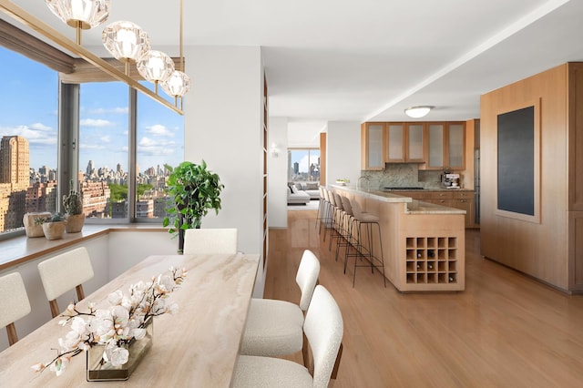 dining space with light wood-type flooring and a city view