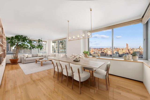 dining area with light wood-style floors and a view of city