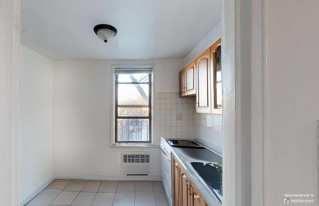 kitchen with light tile patterned floors, decorative backsplash, radiator heating unit, light countertops, and a sink